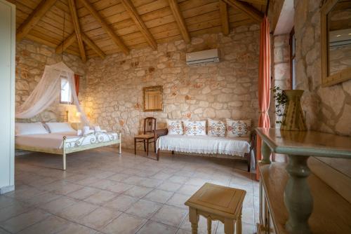 瓦西里科斯塔佩特里那米尔提斯石屋旅馆的一间设有两张床和石墙的房间