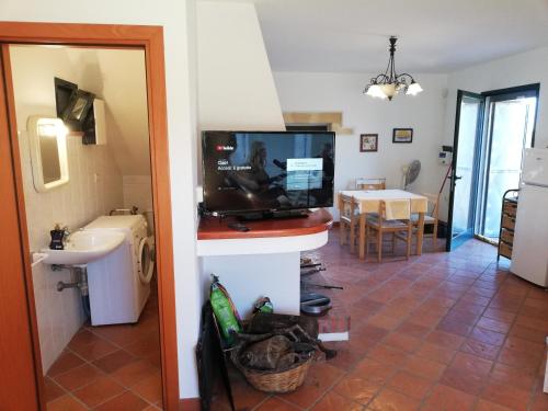 索尔索Villa Tirso的带电视的客厅和带桌子的厨房