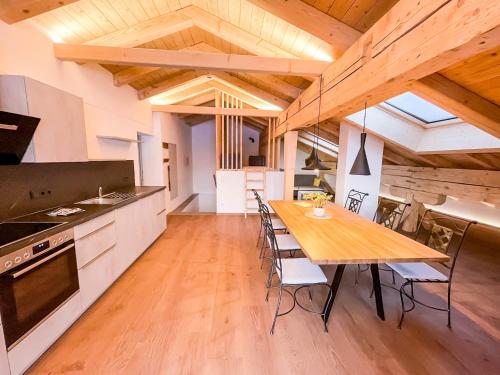 滕嫩山麓圣马丁Glüxplatzl Appartements am Wald的厨房以及带木桌的用餐室。