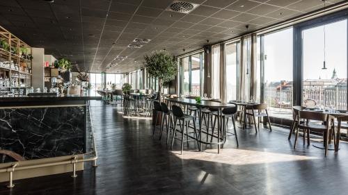 松兹瓦尔Clarion Hotel Sundsvall的窗户间内带桌椅的酒吧
