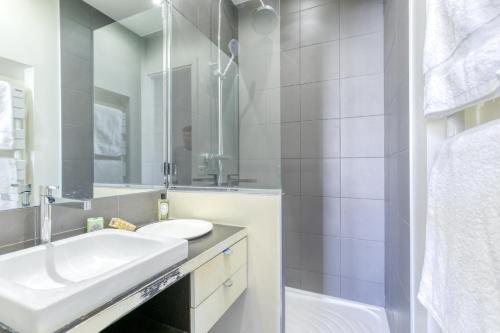 塞纳河畔讷伊Superbe appart de 129m2, 3 ch-Neuilly 2 min Paris的白色的浴室设有水槽和镜子