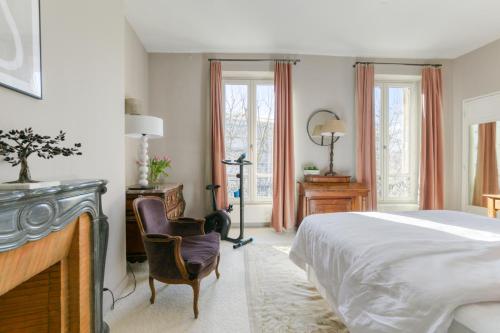塞纳河畔讷伊Superbe appart de 129m2, 3 ch-Neuilly 2 min Paris的卧室配有一张床、一张桌子和椅子
