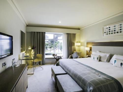 波特马诺克Portmarnock Resort & Jameson Golf Links的酒店客房设有一张大床和一台电视。