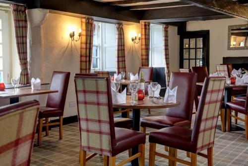 德里门The Winnock Hotel的用餐室设有桌椅和窗户。