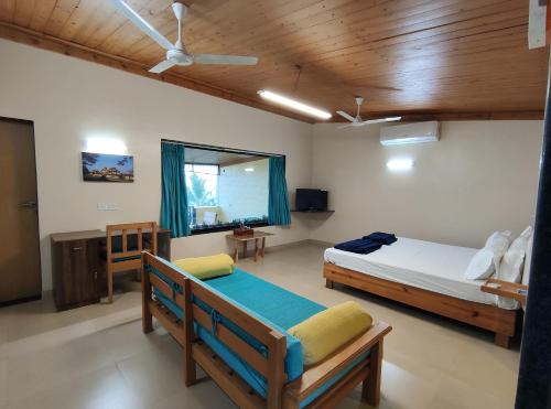 拉特纳吉里Windsongs A Premium Seaview Tropical Village的一间卧室设有两张床和窗户。
