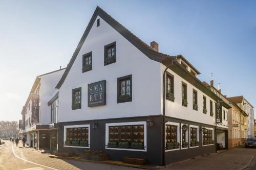 洪堡SMARTY Hotel Euler Homburg, Saar - KONTAKTLOSER SELF CHECK-IN的街道上白色的建筑,有黑色的修饰