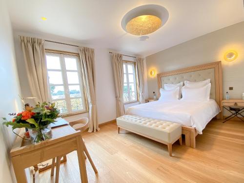 圣艾米隆Petit Monlot - Saint-Emilion的卧室配有一张白色的大床和一张桌子