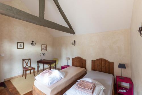 La Bourguignonne的一间卧室配有两张床、一张桌子和一把椅子