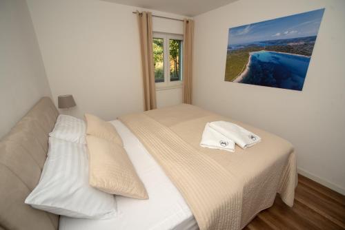 兹曼Villa Median的一间卧室配有一张带白色床单的床和一扇窗户。