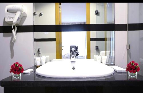 科威特Panorama Hotel Kuwait的一间带白色水槽和电话的浴室