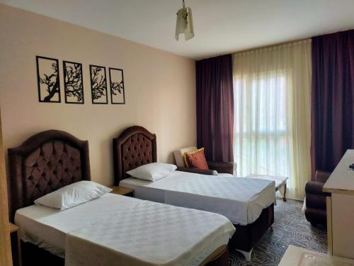 贝利克杜祖图亚普彩虹套房公寓式酒店的酒店客房设有两张床和窗户。