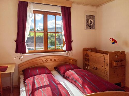 伦山前比绍夫斯海姆Familienferienwohnung Villa Zaunkönigin的一间卧室配有一张带红色枕头的床和一扇窗户