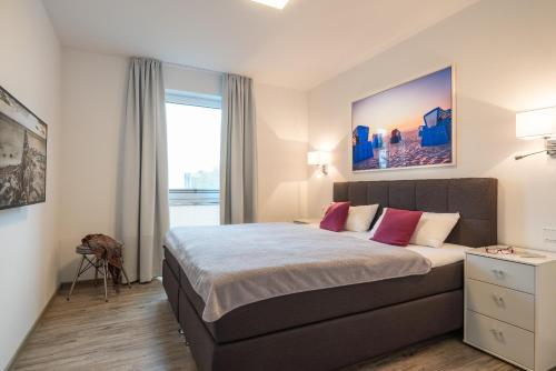 加兹尤瑟多姆Appartement "Seeadler" - Oase am Haff的一间卧室配有一张带红色枕头的大床