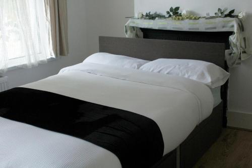 伦敦cozy rooms in London Townhouse fast links to Central的一间卧室配有两张带白色枕头的床