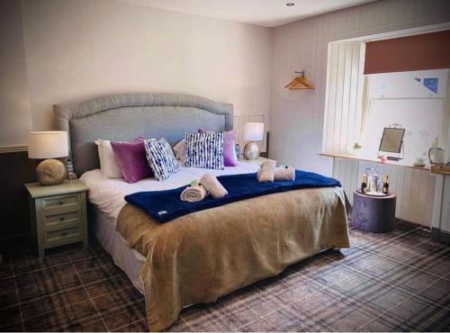 AbernethyThe Crees Room only NO BAR OR RESTAURANT的一间卧室配有一张大床,提供紫色和蓝色枕头