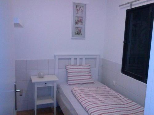 ArguineguínApartamento dos dormitorios的一间白色的小卧室,配有一张床和一张桌子