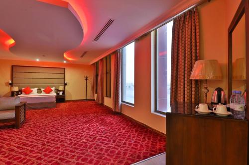 Al Nairyahفــنــدق بـفــن Hotel的酒店客房,配有床铺和红地毯