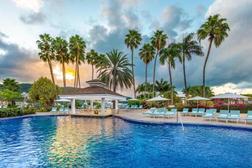 欧丘里欧牙买加月宫酒店的一个带椅子和棕榈树的度假村游泳池