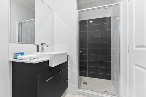 邦加里Bribie Getaway Villa的带淋浴、盥洗盆和镜子的浴室