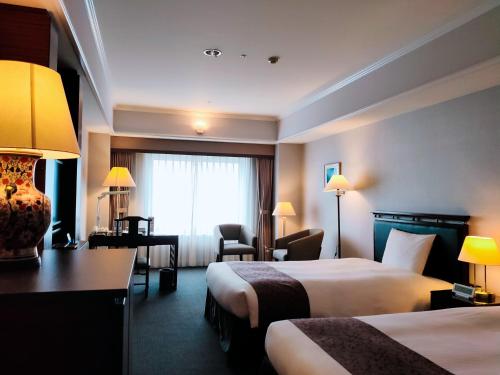 仓敷仓敷皇家艺术酒店的酒店客房设有两张床和窗户。