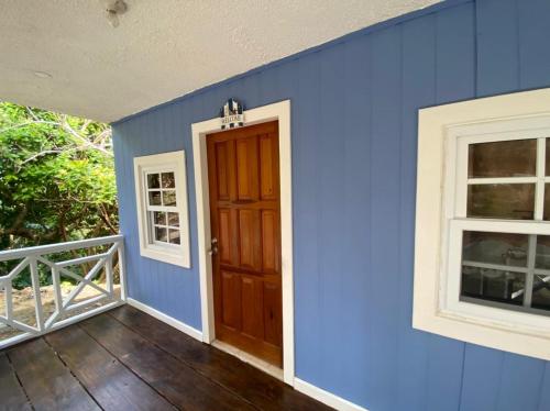 Six HutsBahia Azul Apartment的一间蓝色的房间,设有门和两个窗户