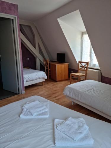 ApchonAuberge le Cheylet的一间卧室配有两张带白色床单和桌子的床