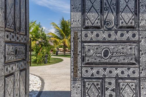 艾湄湾Emocean Beach Boutique Dive Resort的棕榈树建筑的两扇门