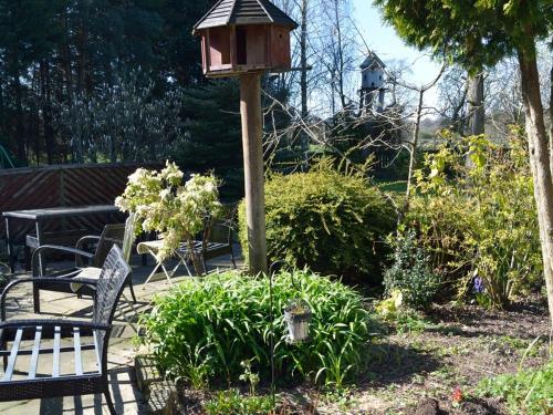 克努斯福德Laburnum Cottage Guest House的花园里的鸟屋和长凳
