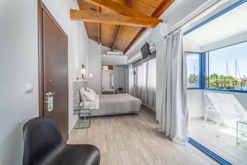 雷夫卡达镇Ianos Bay的一间卧室设有一张床和一个大窗户