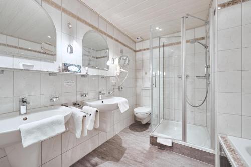 巴登韦勒Hotel Ritter Badenweiler的带淋浴、盥洗盆和卫生间的浴室