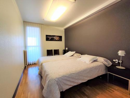 潘普洛纳Mendebaldea Suite Premium的一间卧室设有两张床和大窗户