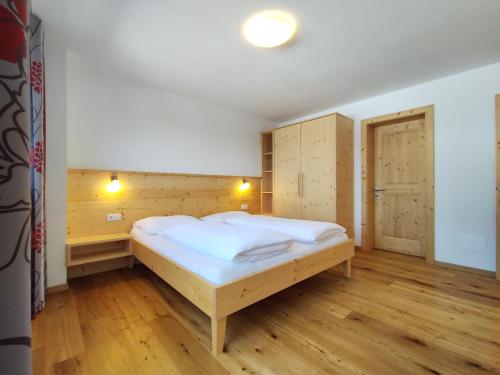 布列瑟农Zimmererhof的一间卧室配有一张床,铺有木地板