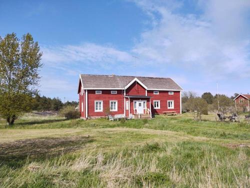 弗格罗Sommarö Stugor的田间中的一个红色房子