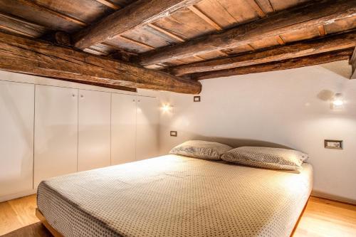 罗马Casa Vantaggio的一间卧室设有床铺和木制天花板