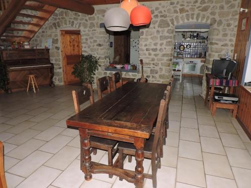 GrazacLa sérénité的带厨房的客房内的一张木桌和椅子