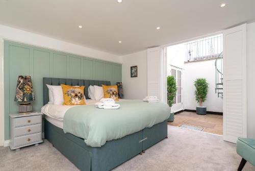 切尔滕纳姆Stunning 2 Bed in the Heart of Cheltenham!的一间卧室配有一张带橙色枕头的大床