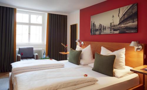 林道恩格尔林道尔啤酒和葡萄酒酒吧酒店的红色墙壁的酒店客房内的两张床