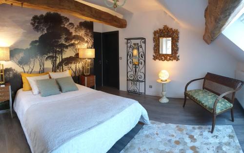 Nevy-sur-SeilleMaison Bélénos的一间卧室配有一张大床和一把椅子