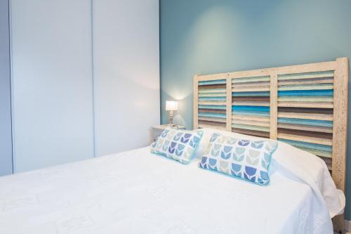 帕特里莫尼奥U Fornu的卧室配有白色的床和木制床头板