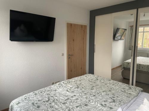 巴贝Traumferienwohnung Ostseebad Baabe - Rügen的卧室配有一张床和壁挂式平面电视。