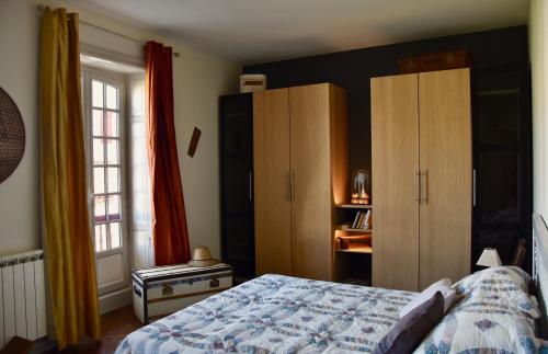 乌瑞基尼Appartement Erlandebaita Centre bourg 3 personnes的一间卧室配有一张床和木制橱柜