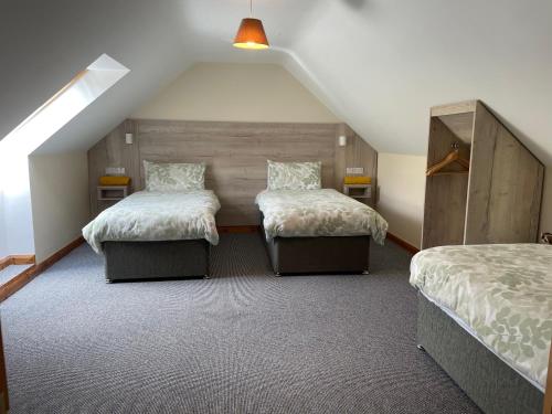库申多尔塔瓦纳格哈尼乡村民宿的阁楼卧室设有两张床和倾斜的天花板。