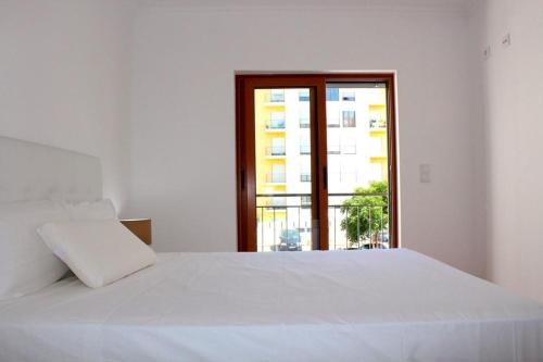 阿马多拉Damaia Apartment的窗户客房内的一张白色床