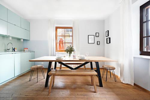 萨尔茨堡numa I Flute Apartments的一间厨房,内设一张木桌和椅子