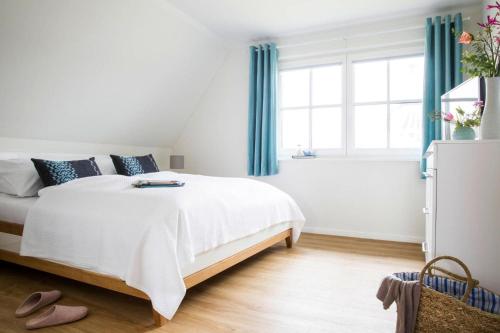 富伦多夫Holiday house, Fuhlendorf的一间卧室配有白色的床和蓝色窗帘