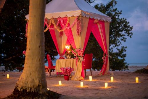 哈夫洛克岛Coral Reef Resort & Spa, Havelock的海滩上的帐篷,配有桌子和蜡烛