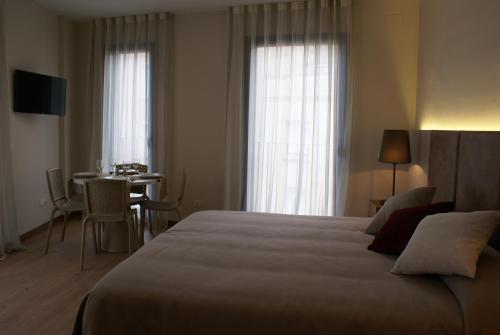 菲格拉斯K公寓酒店的酒店客房设有一张大床和一张桌子。