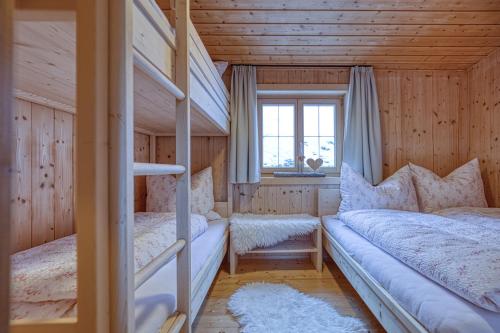 查贡斯Nüggili's Maisäß的一间卧室设有两张双层床和一扇窗户。
