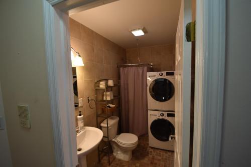 泽西市Riverhouse Extended Stay Apartment的浴室配有卫生间水槽和洗衣机。