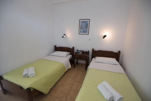 纳乌萨卡捷琳娜客房旅馆的客房设有两张床和一个带桌子的床头柜。